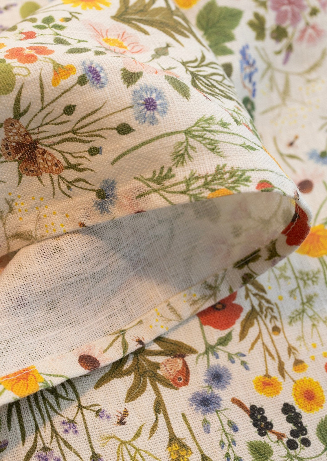 A linen tea towel with multicolor floral/botanical print.