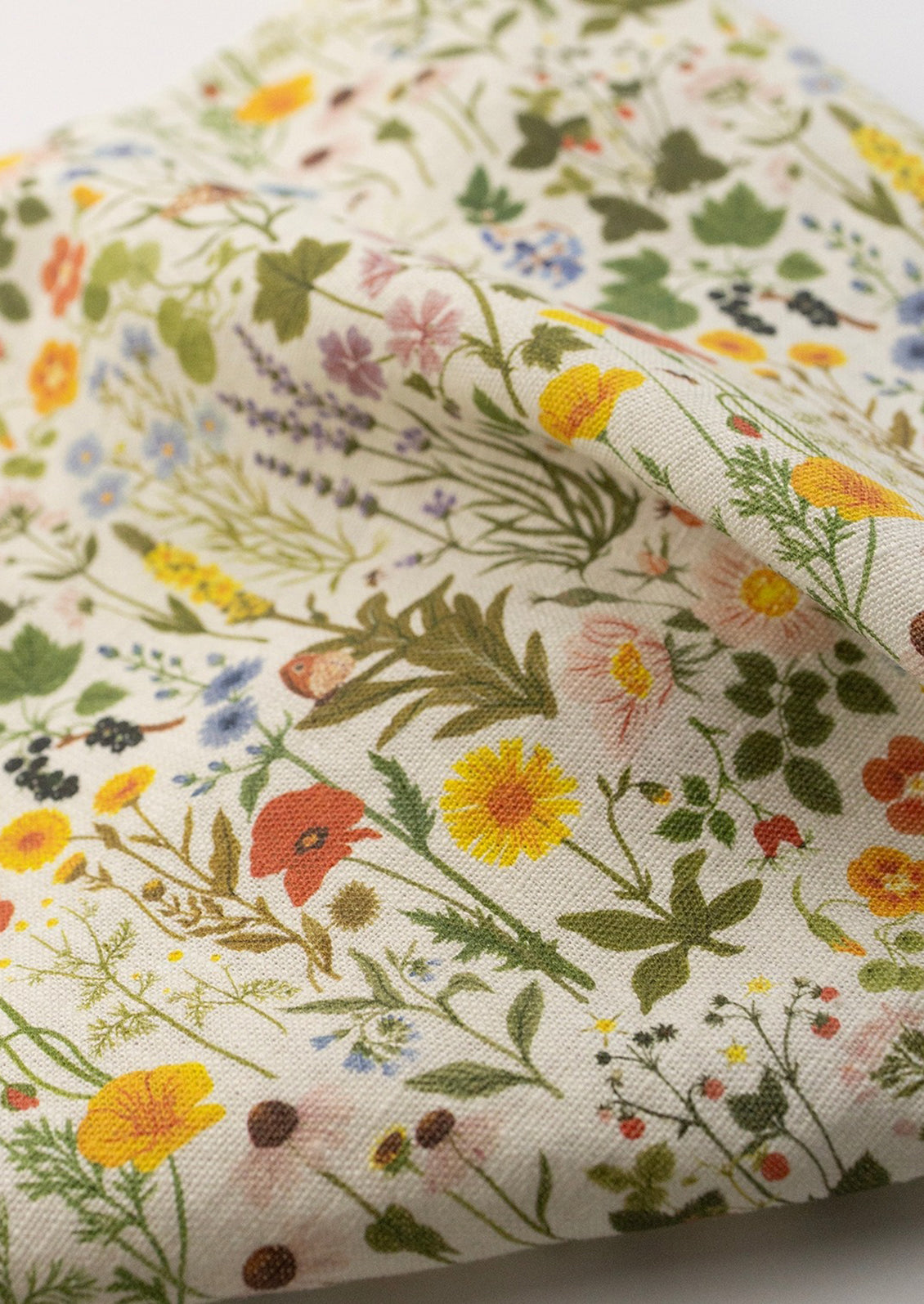 A linen tea towel with multicolor floral/botanical print.