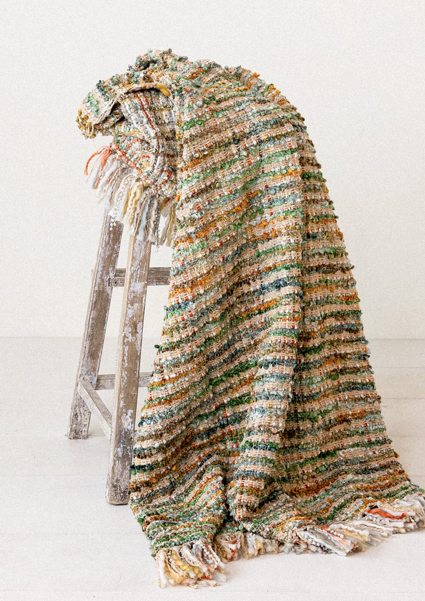 A throw blanket in multicolor boucle tweed.