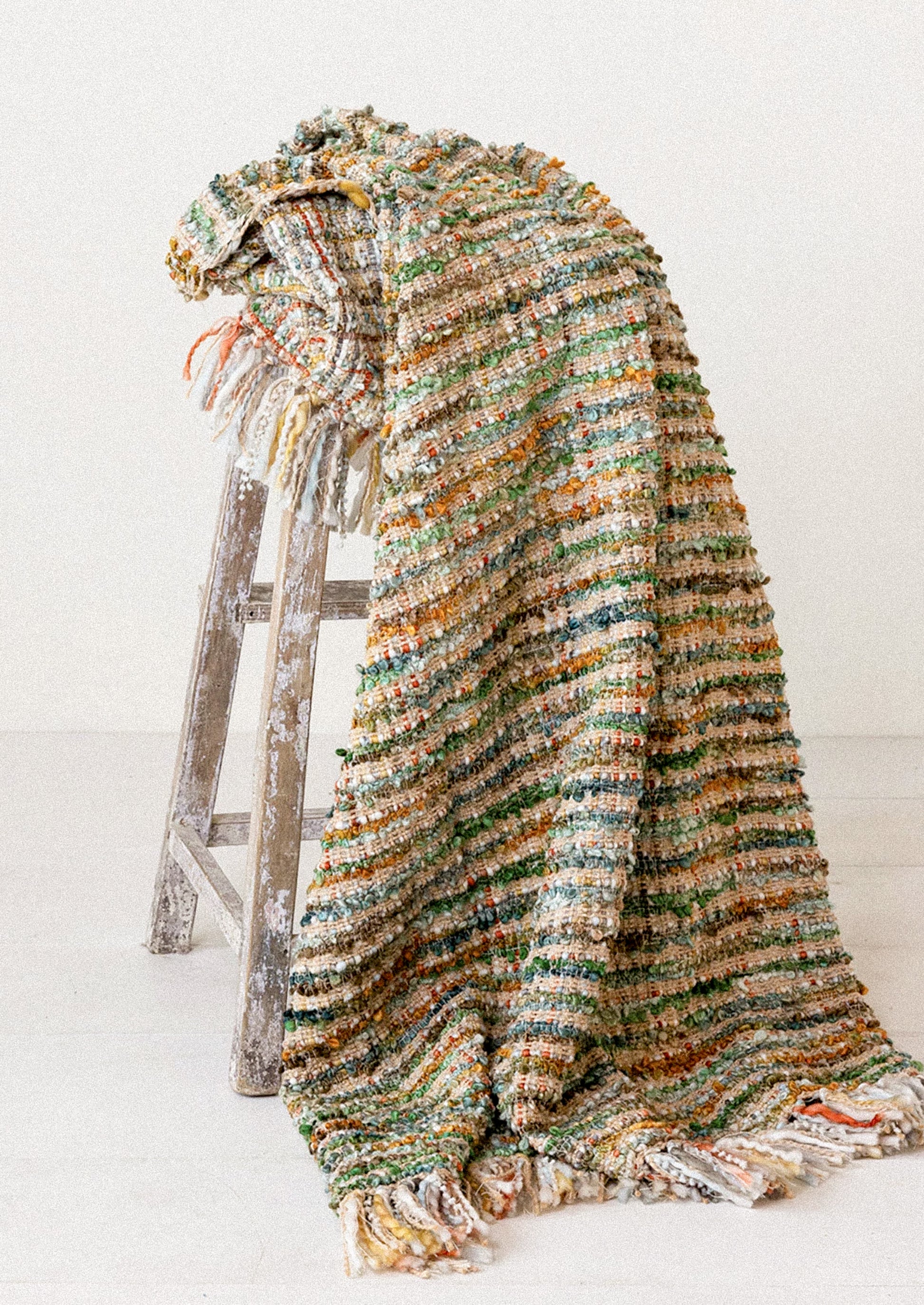 A throw blanket in multicolor boucle tweed.