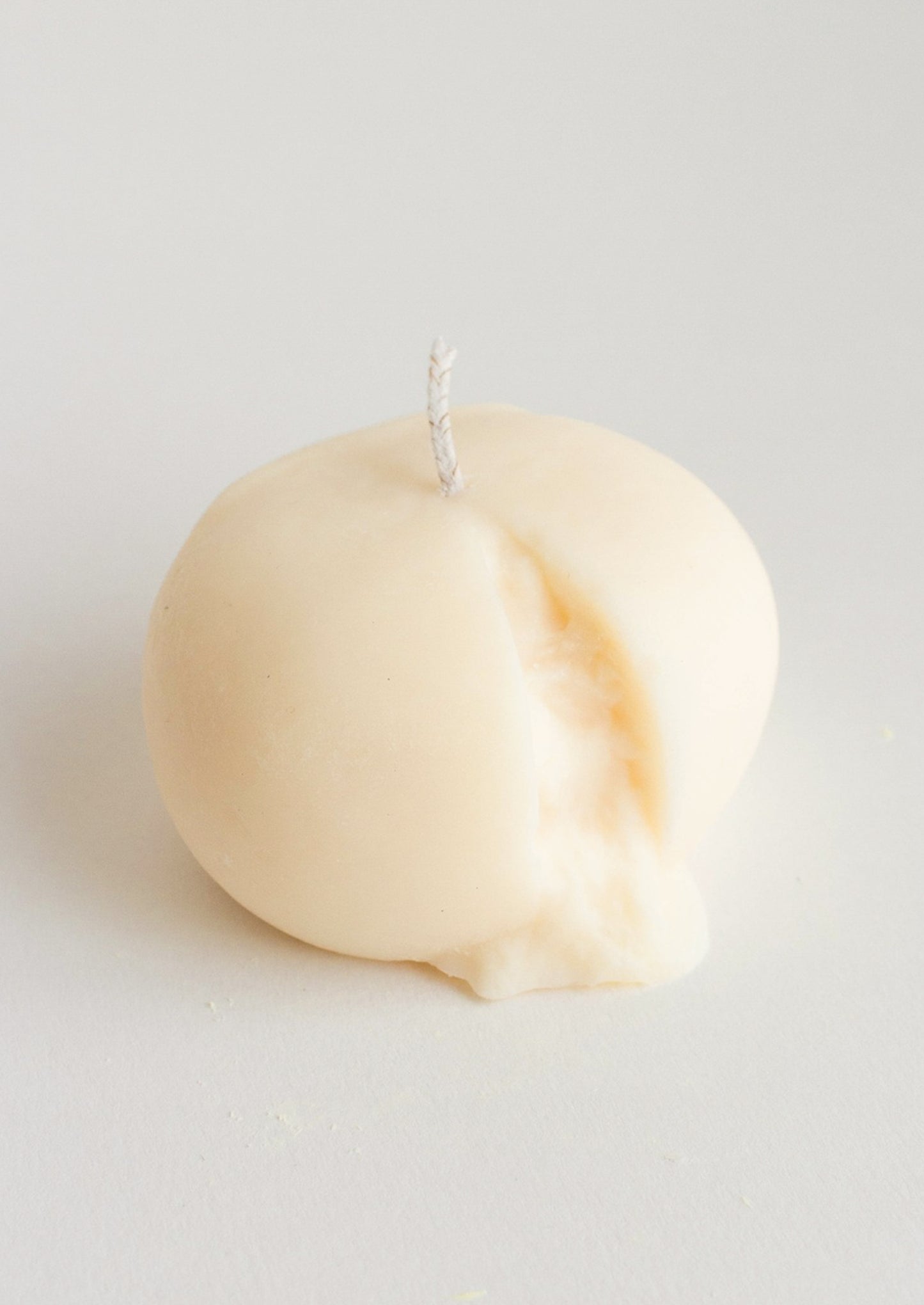 A candle in the shape of a ball of burrata cheese.