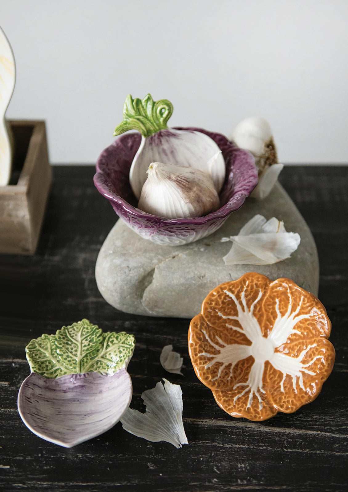 A pair of ceramic nesting bowls that look like orange and purple cabbage.