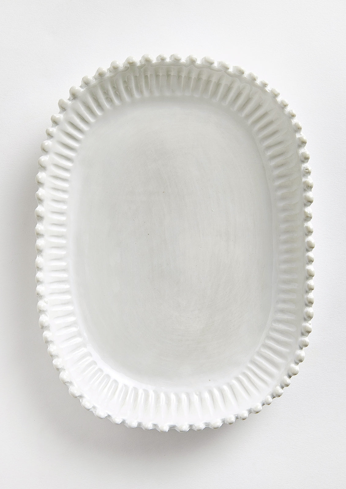 A rectangular ceramic platter in white with rounded edges and hobnail pleated border.