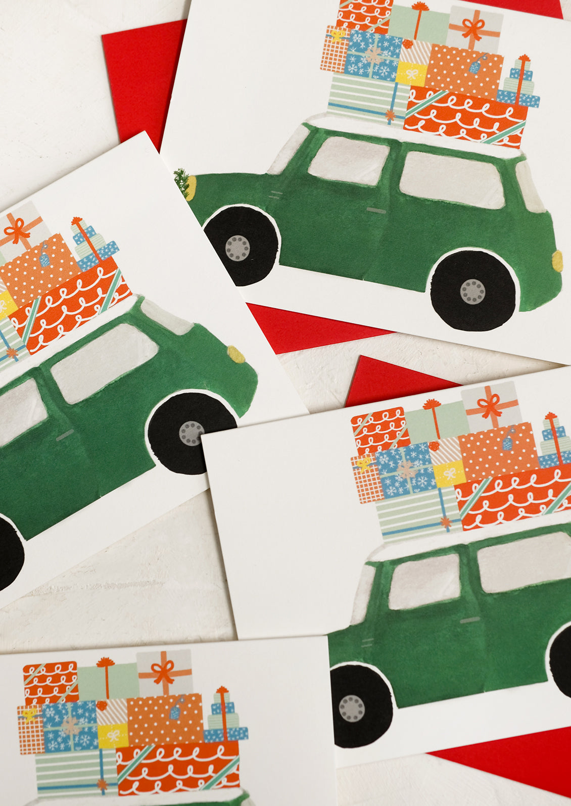 A set of cards picturing green car with presents on top.