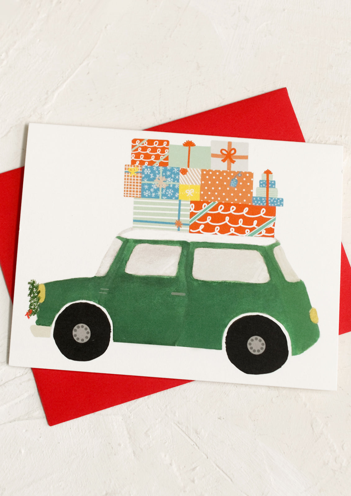 A set of cards picturing green car with presents on top, comes with red envelope.