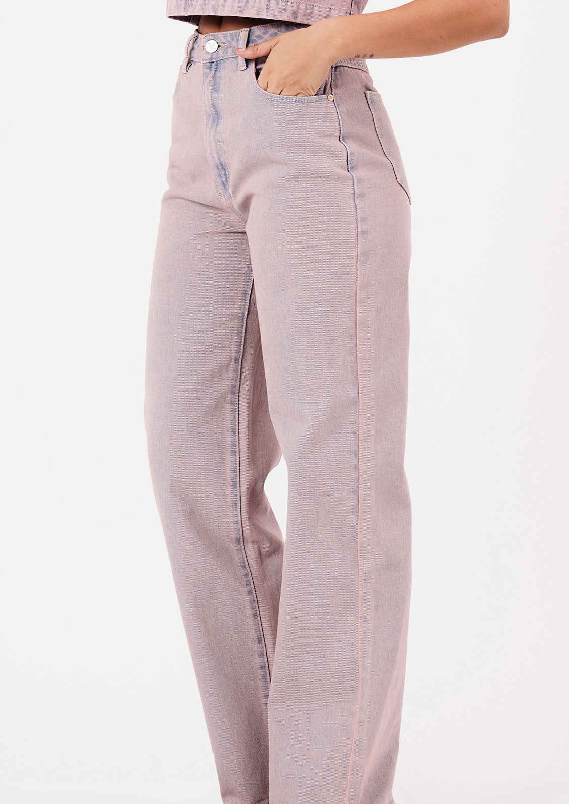 A woman wearing a pair of straight leg jeans in pink tinted wash.