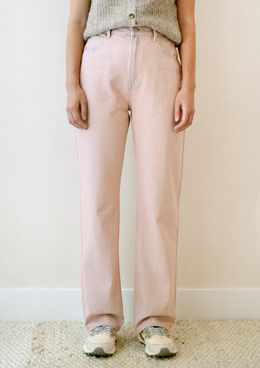 A woman wearing a pair of straight leg jeans in pink tinted wash.