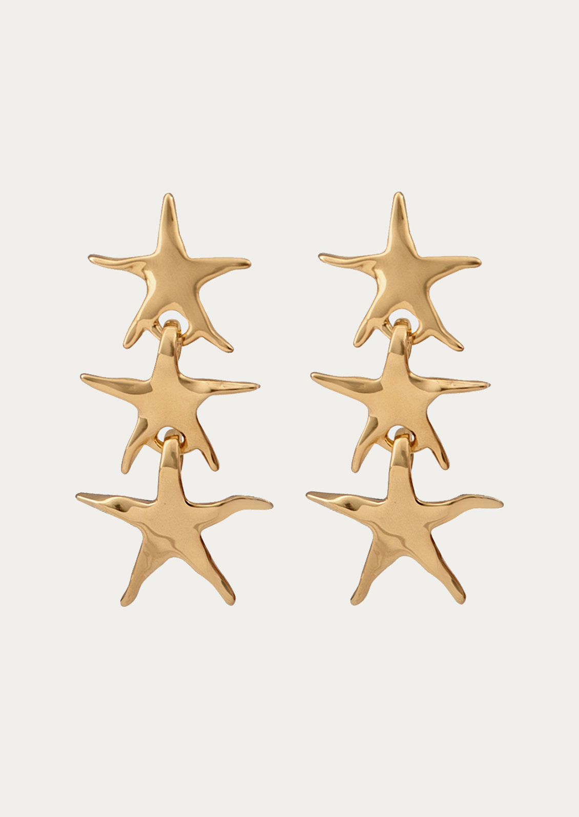 Gold star-shaped earrings on a white background