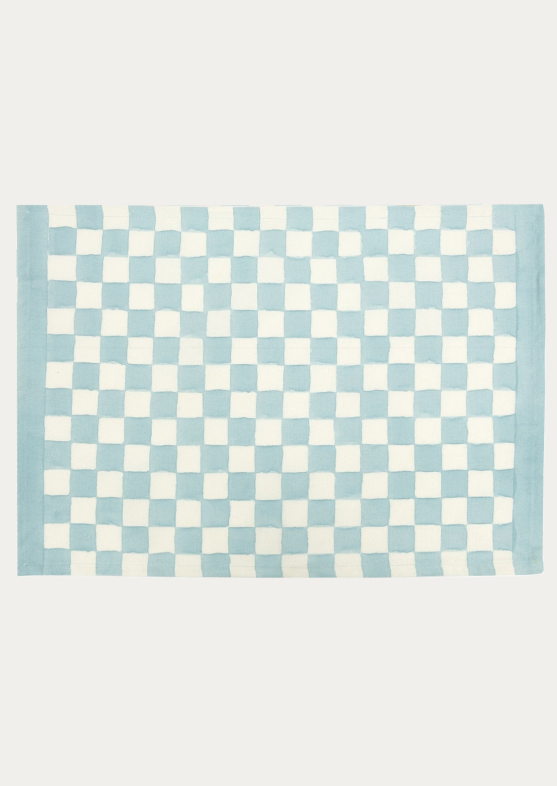 A block printed placemat with checkered pattern in sky blue.