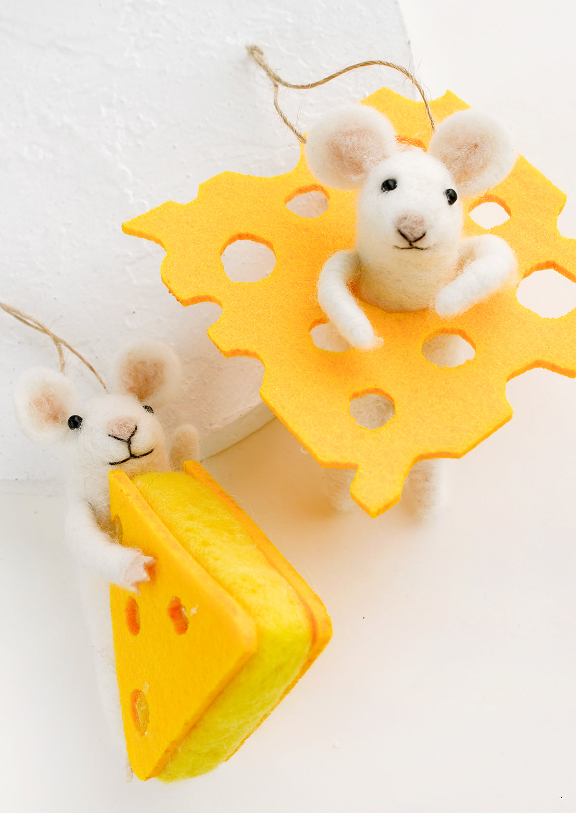 Felted wool ornaments of white mice with cheese.