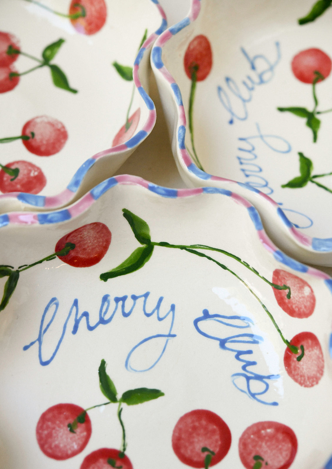 Handmade ceramic dishes with an illustrated cherry design.