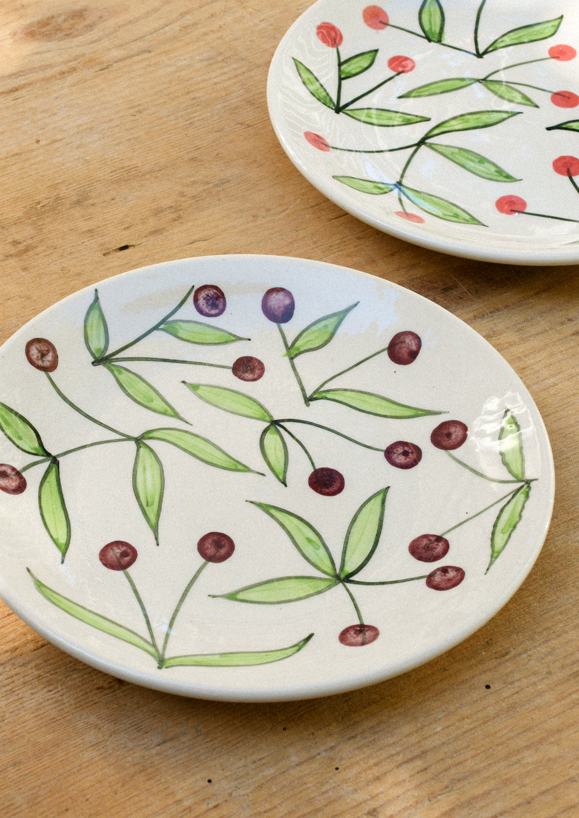 Ceramic plates with illustrated cherries.