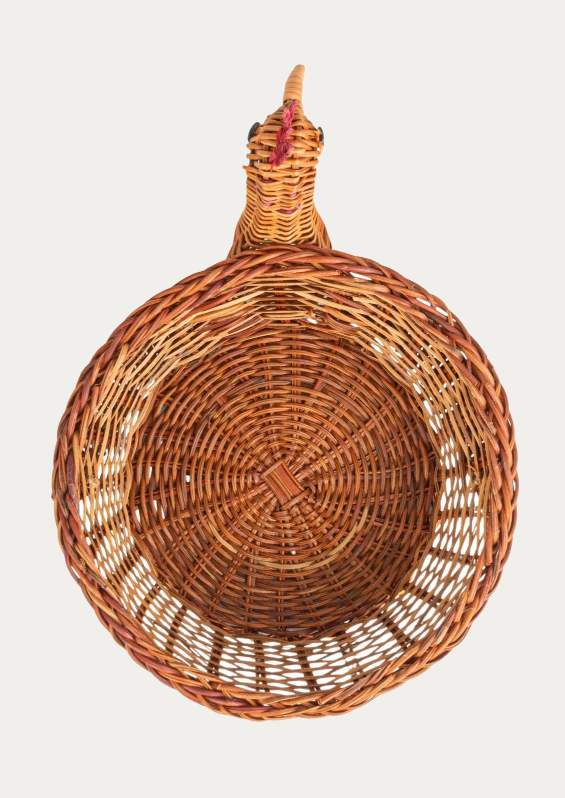 A woven basket with three dimensional chicken head detailing on side.