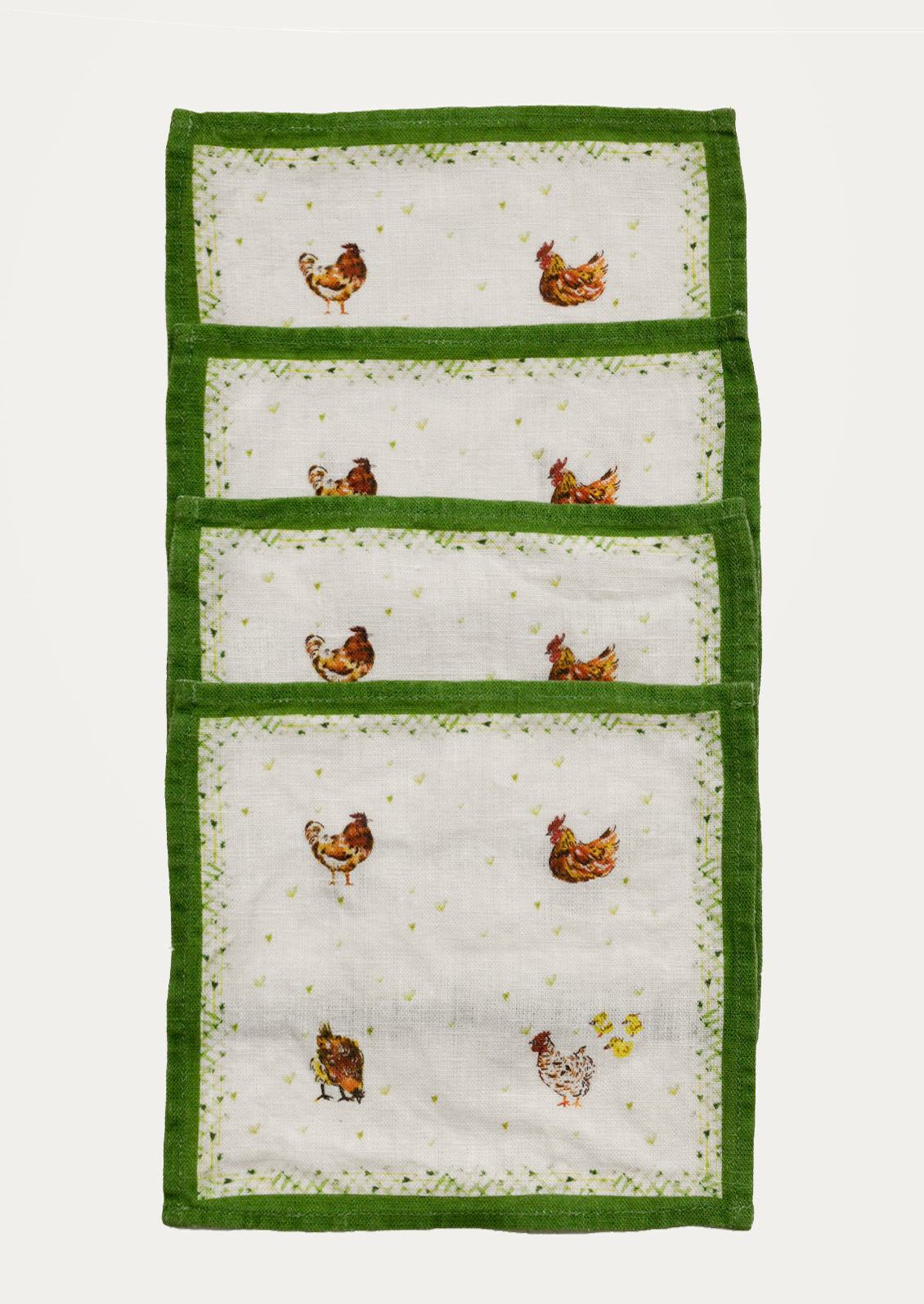 Set of four cocktail napkins with green borders and chicken designs.