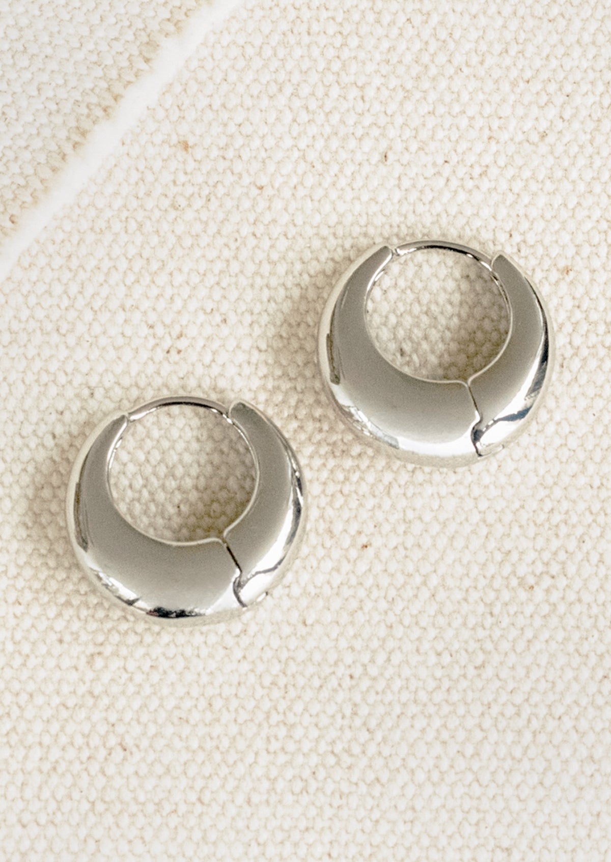 A pair of chubby silver hoop earrings.