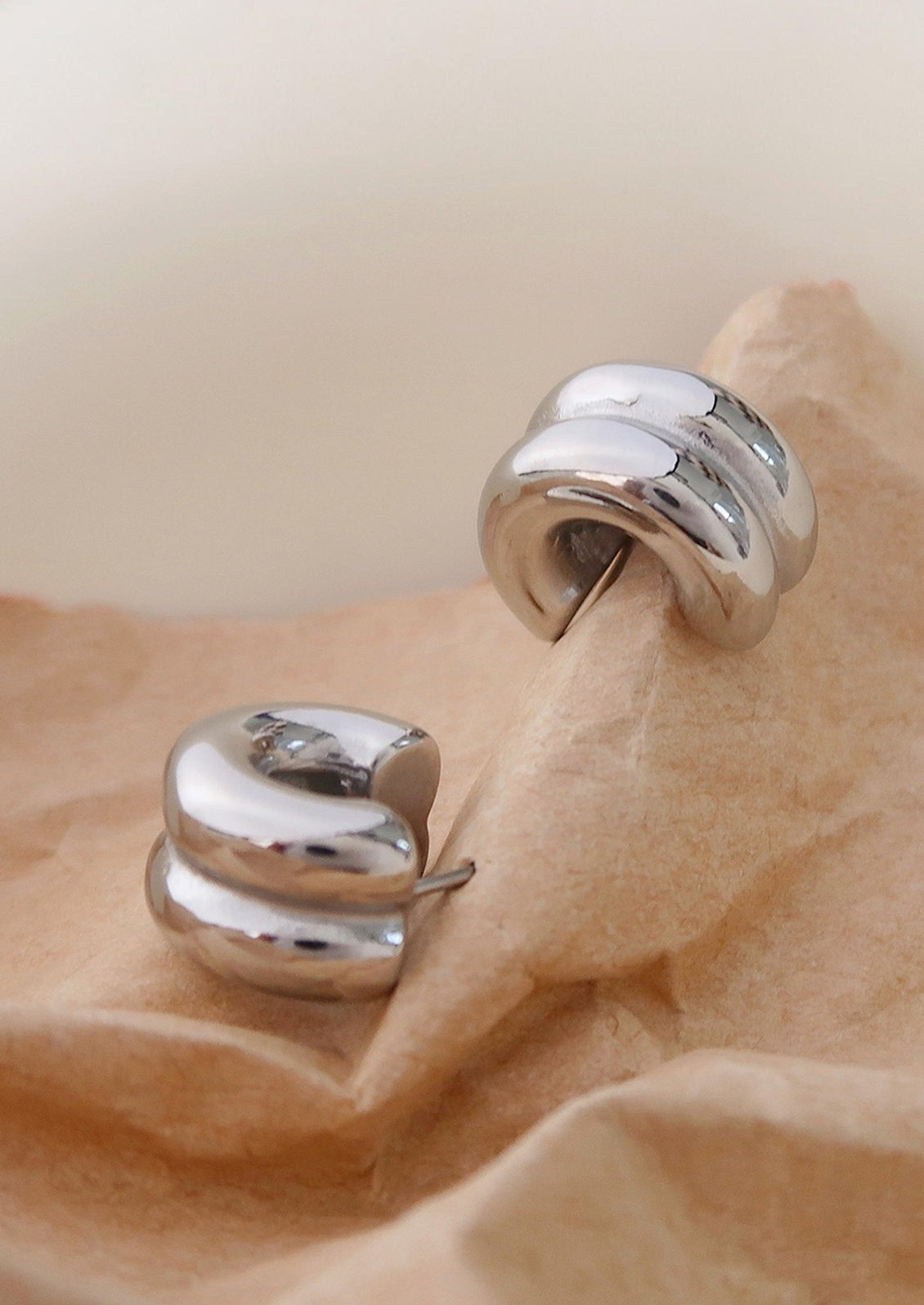A pair of chunky rib textured hoop earrings in silver.