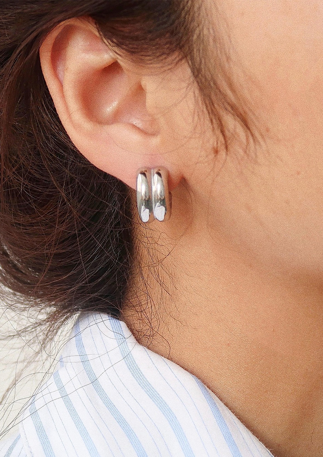A pair of chunky rib textured hoop earrings in silver.