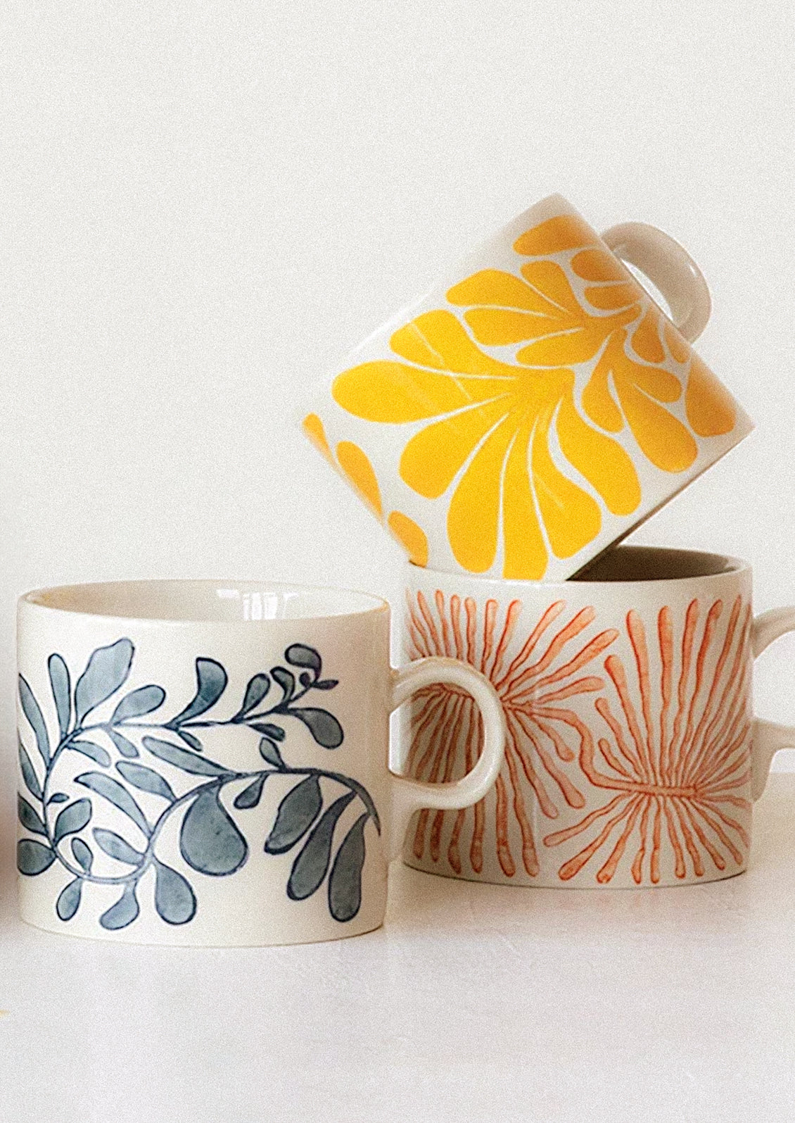Mugs with various seaweed-like patterns in assorted colors.