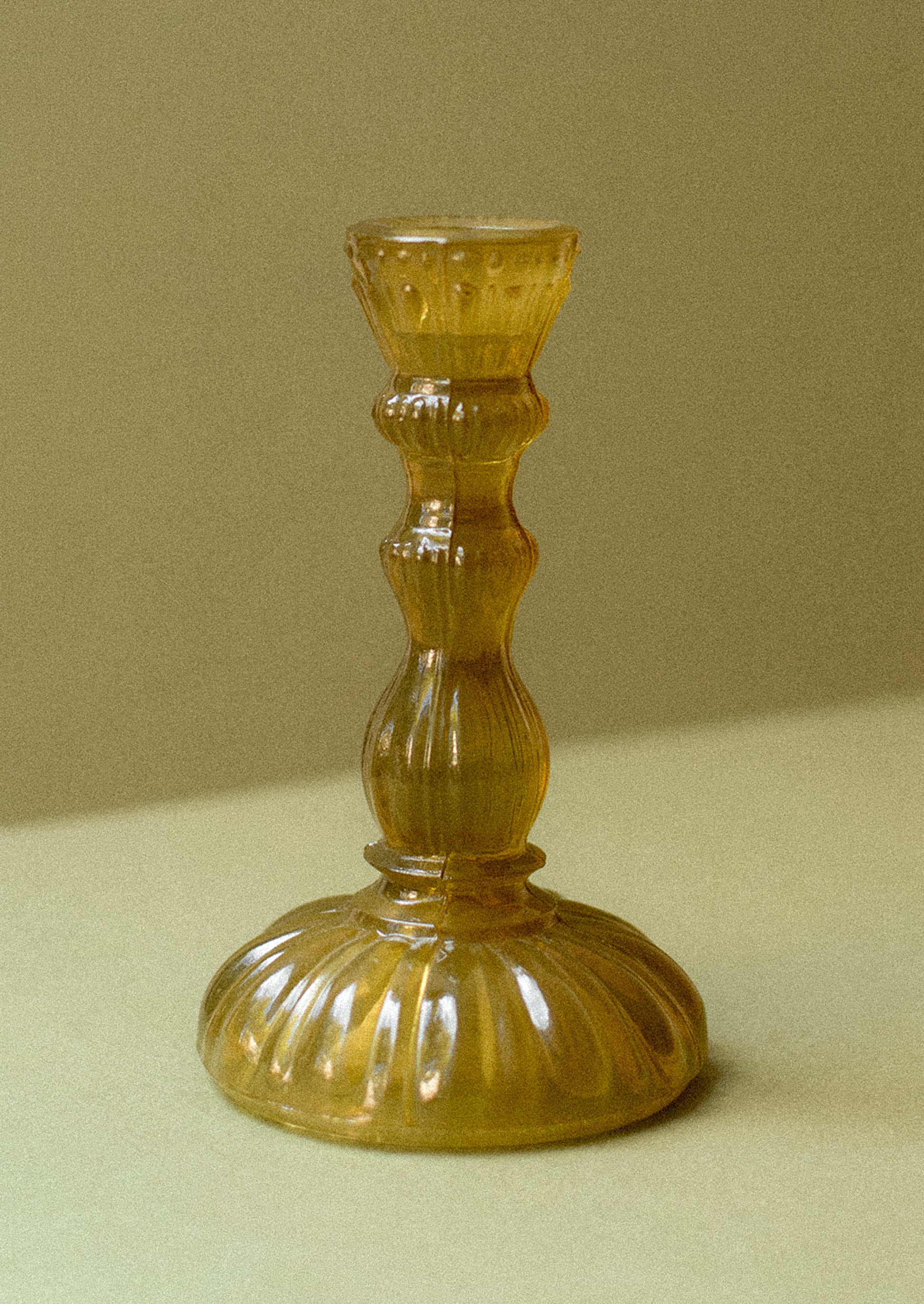 An olive green vintage style taper holder in embossed glass design.