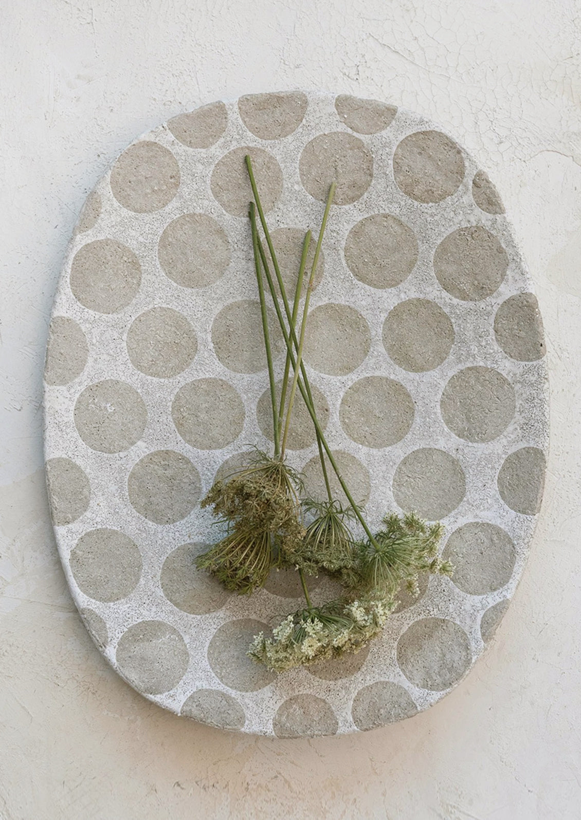 A cement platter with polka dot pattern.