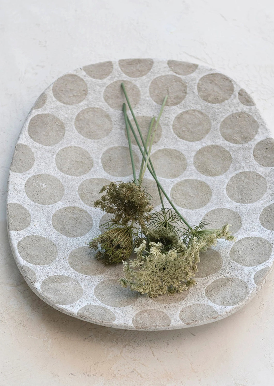 A cement platter with polka dot pattern.