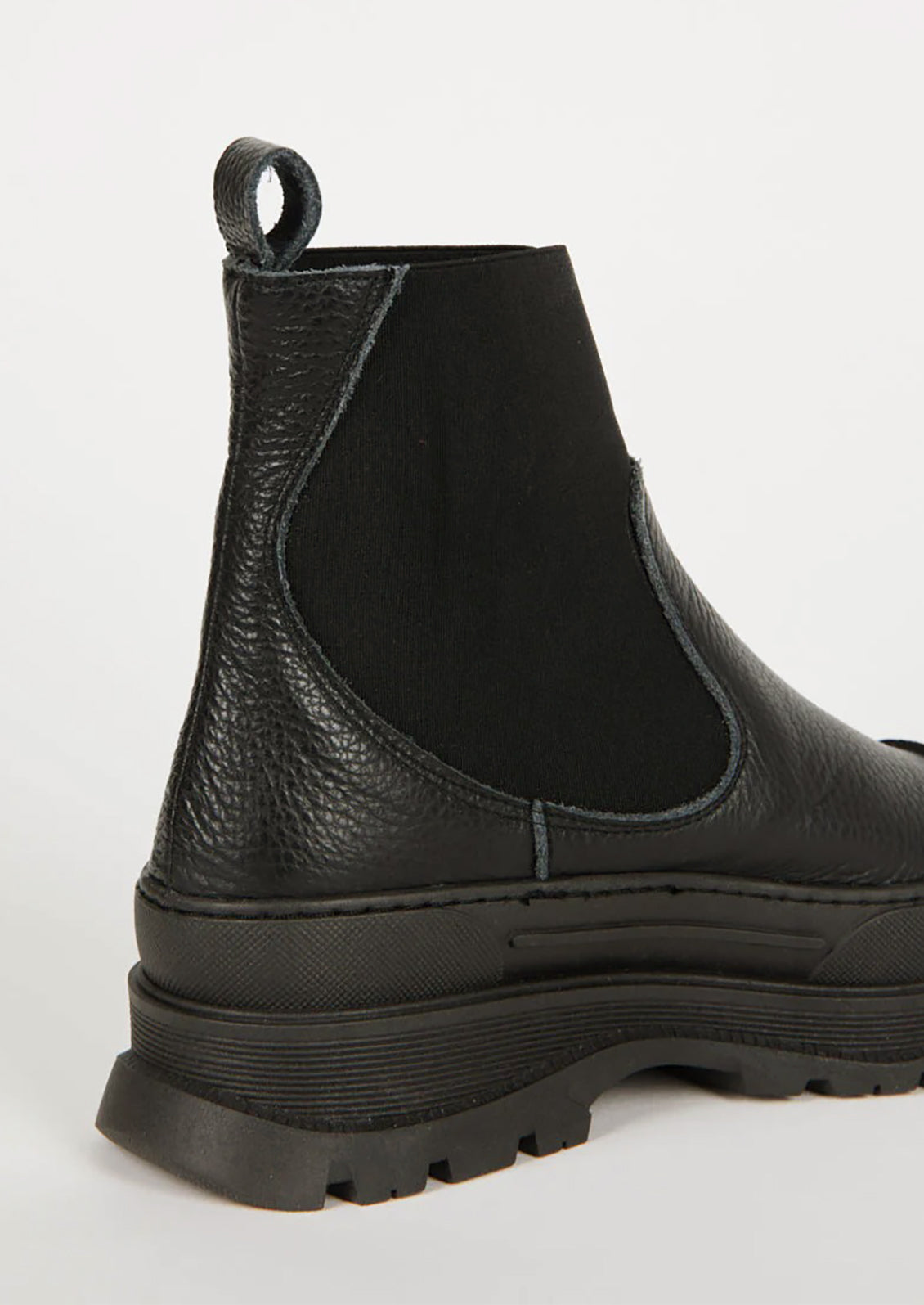 A pair of black boots with elastic ankle, rubber cap toe and chunky lug sole.