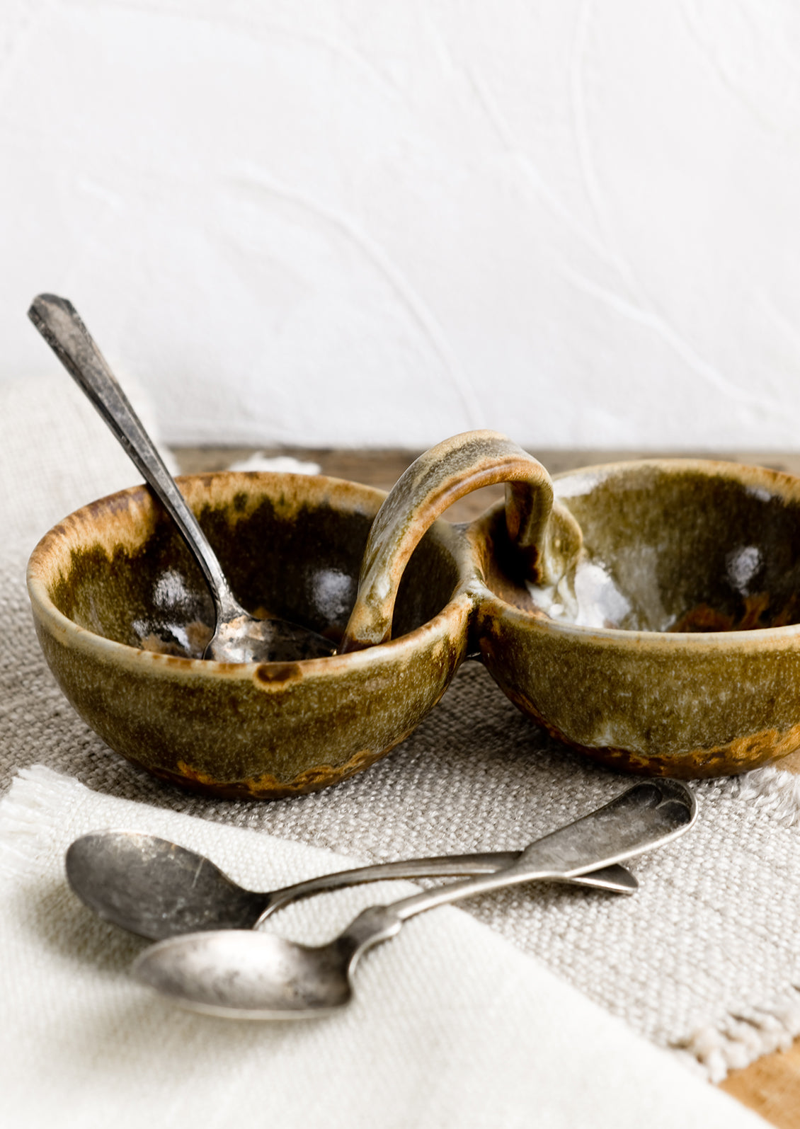 A double cellar ceramic vessel in variegated brown glaze.