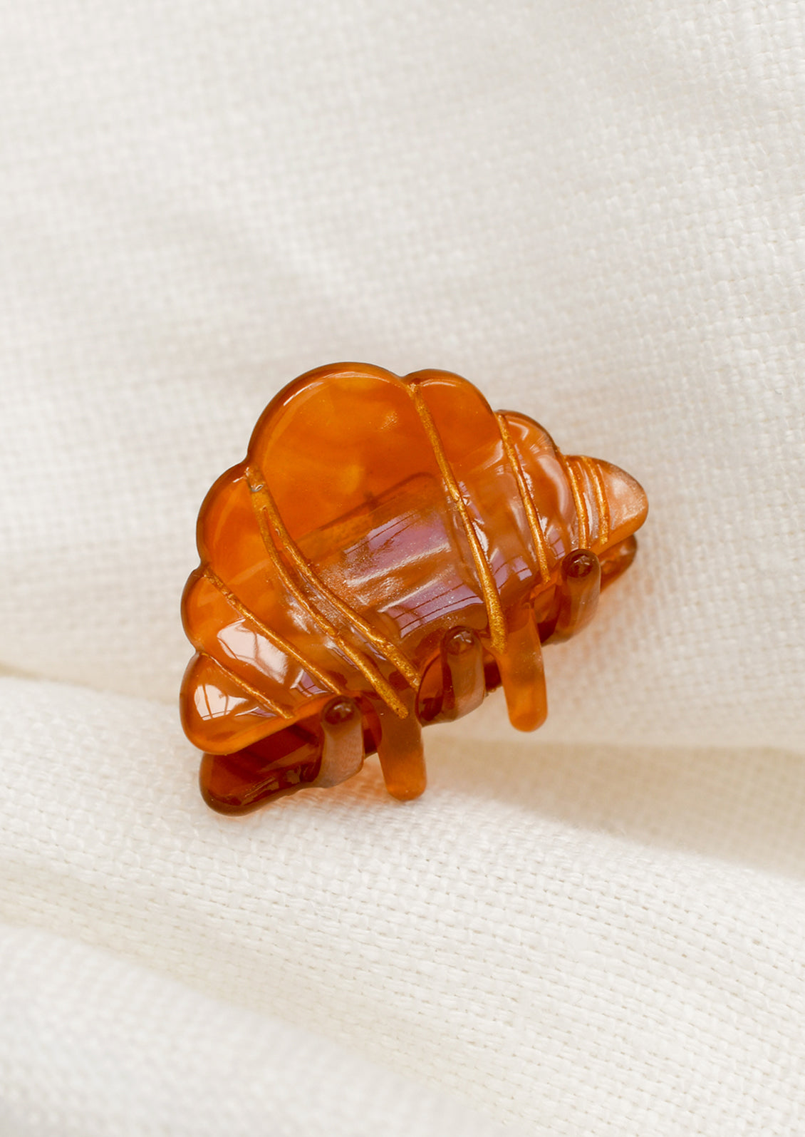 A mini claw in shape of a croissant.