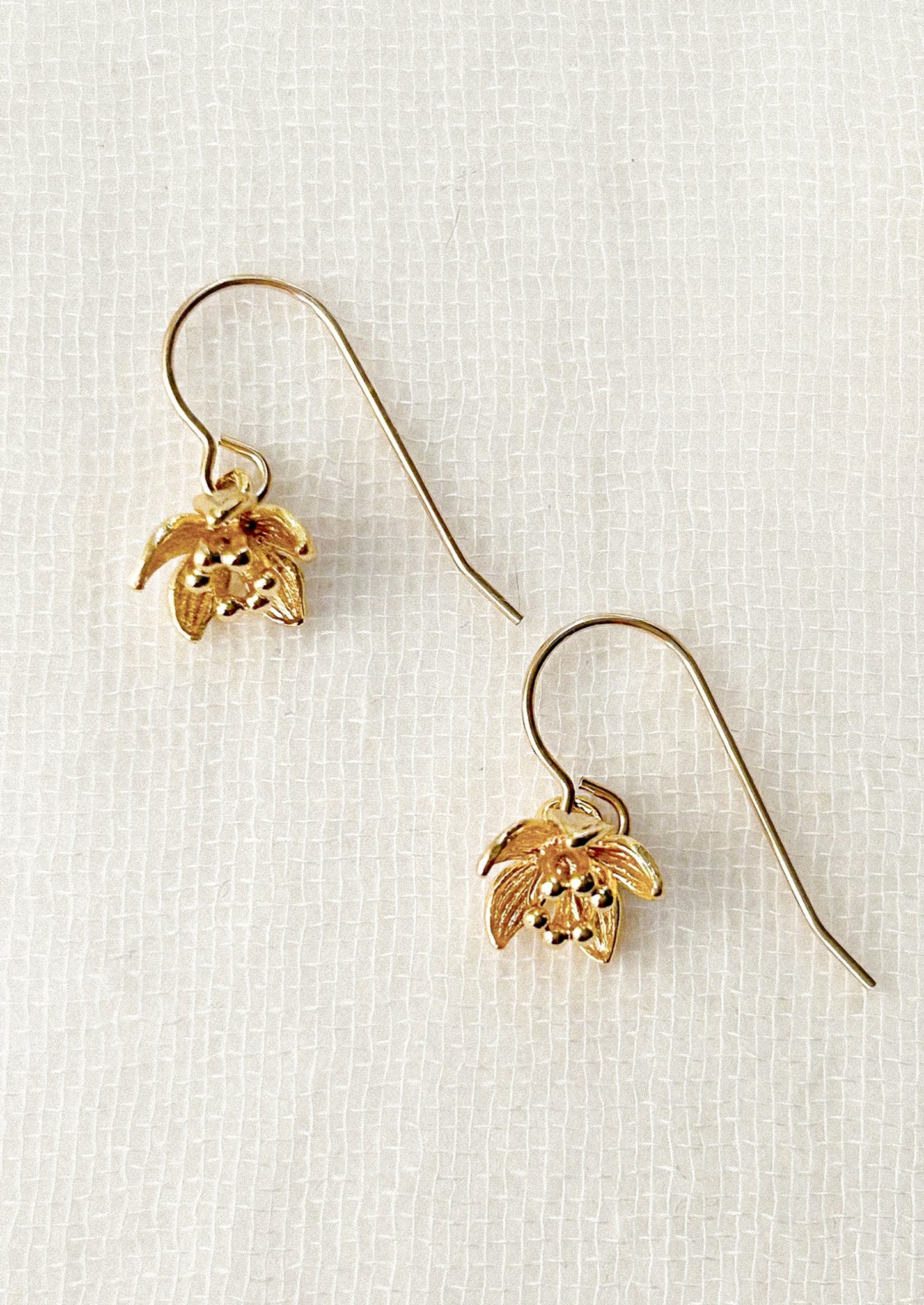 Gold flower-shaped earrings on a white background