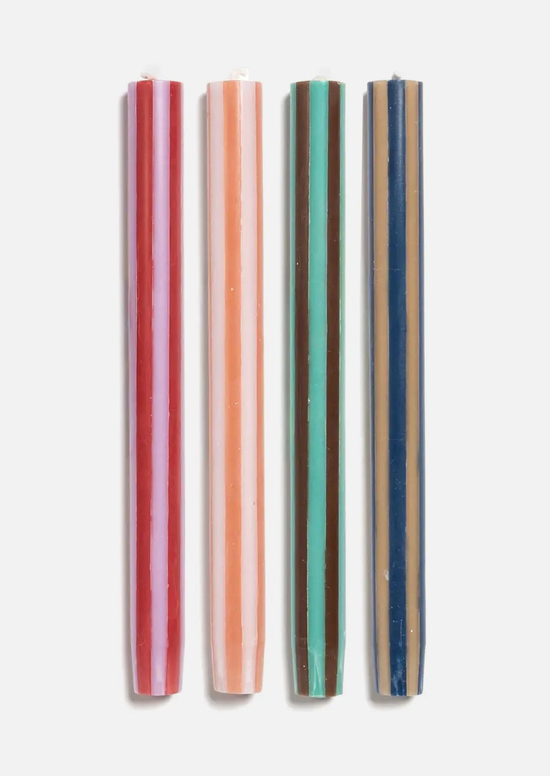 A set of striped taper candles in a mix of earthy hues.