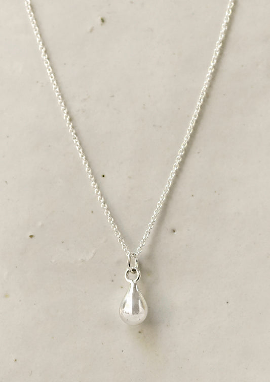 A sterling silver necklace with a dew drop shaped charm.