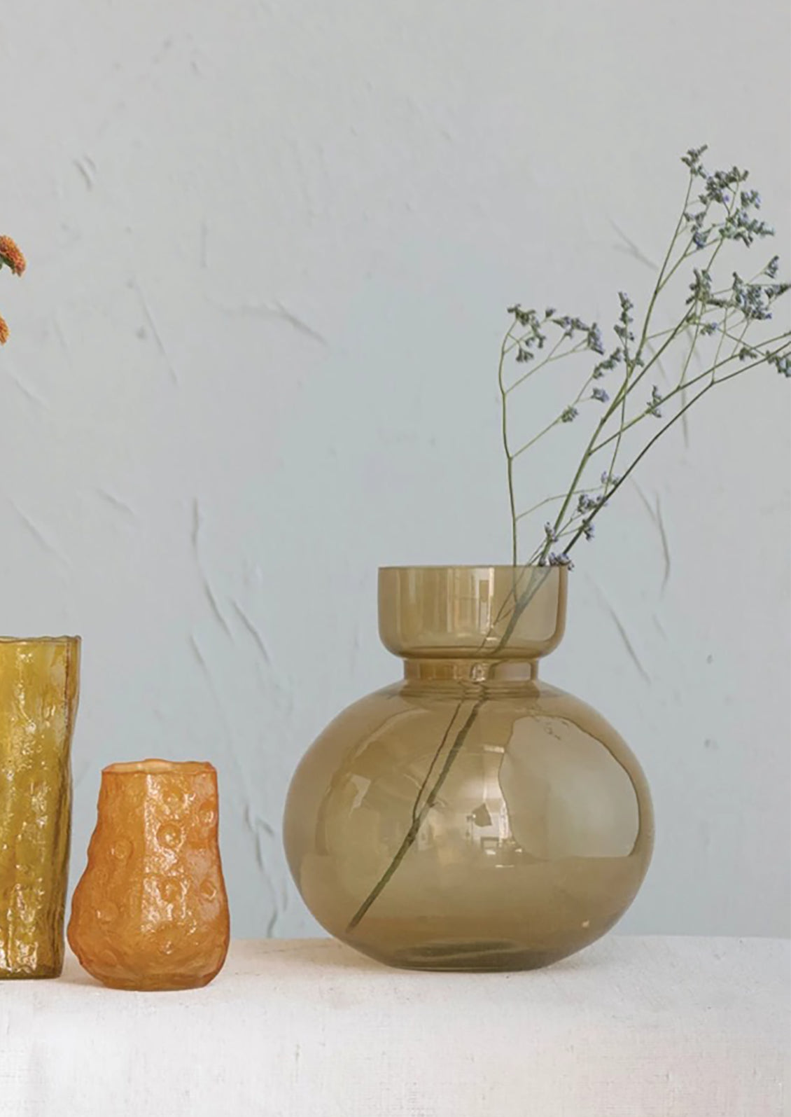 A vase in clear brown glass with round bottleneck shape.