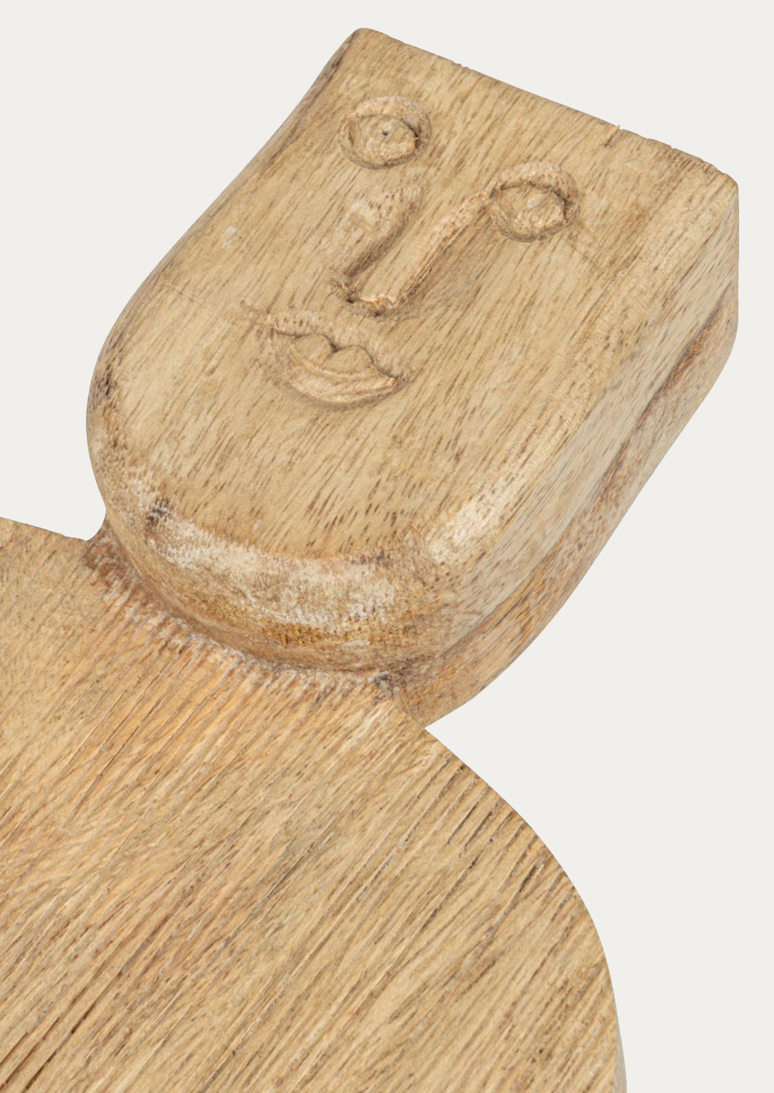 A small wooden serving board with a face carved into the handle.
