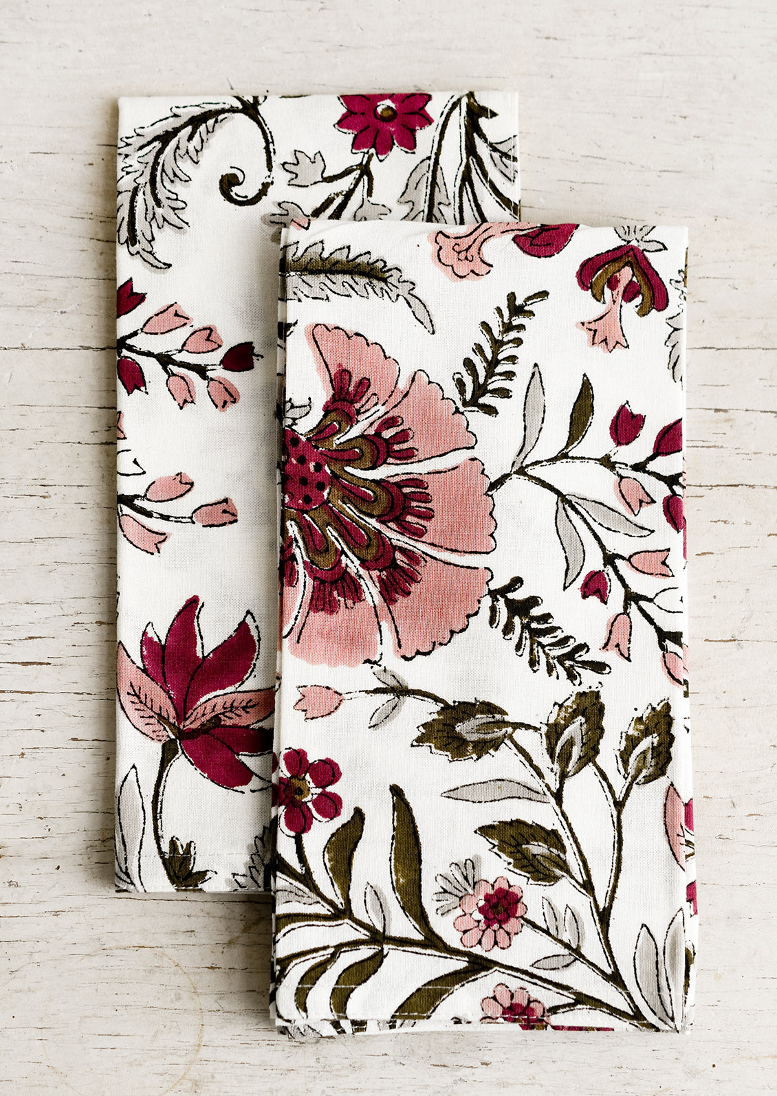 A pair of block printed cotton napkins in mauve and green floral.