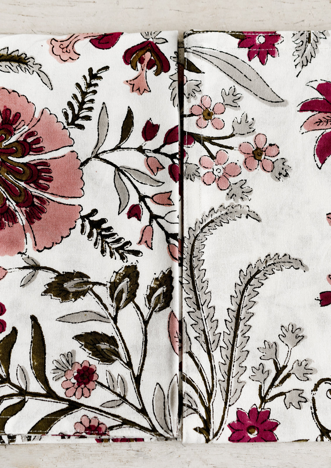 A pair of block printed cotton napkins in mauve and green floral.
