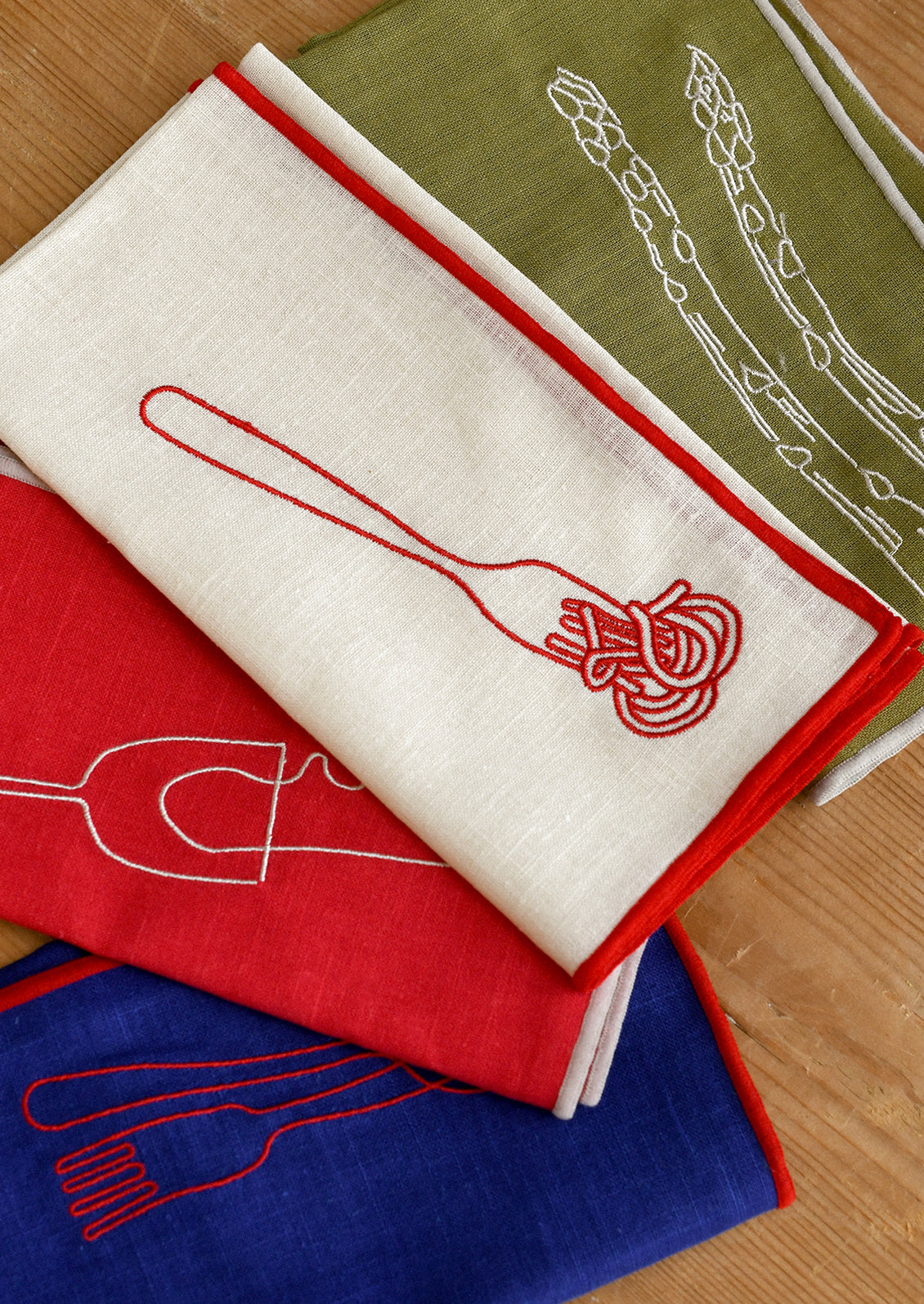 Assorted cloth napkins with food themed embroidered motifs.