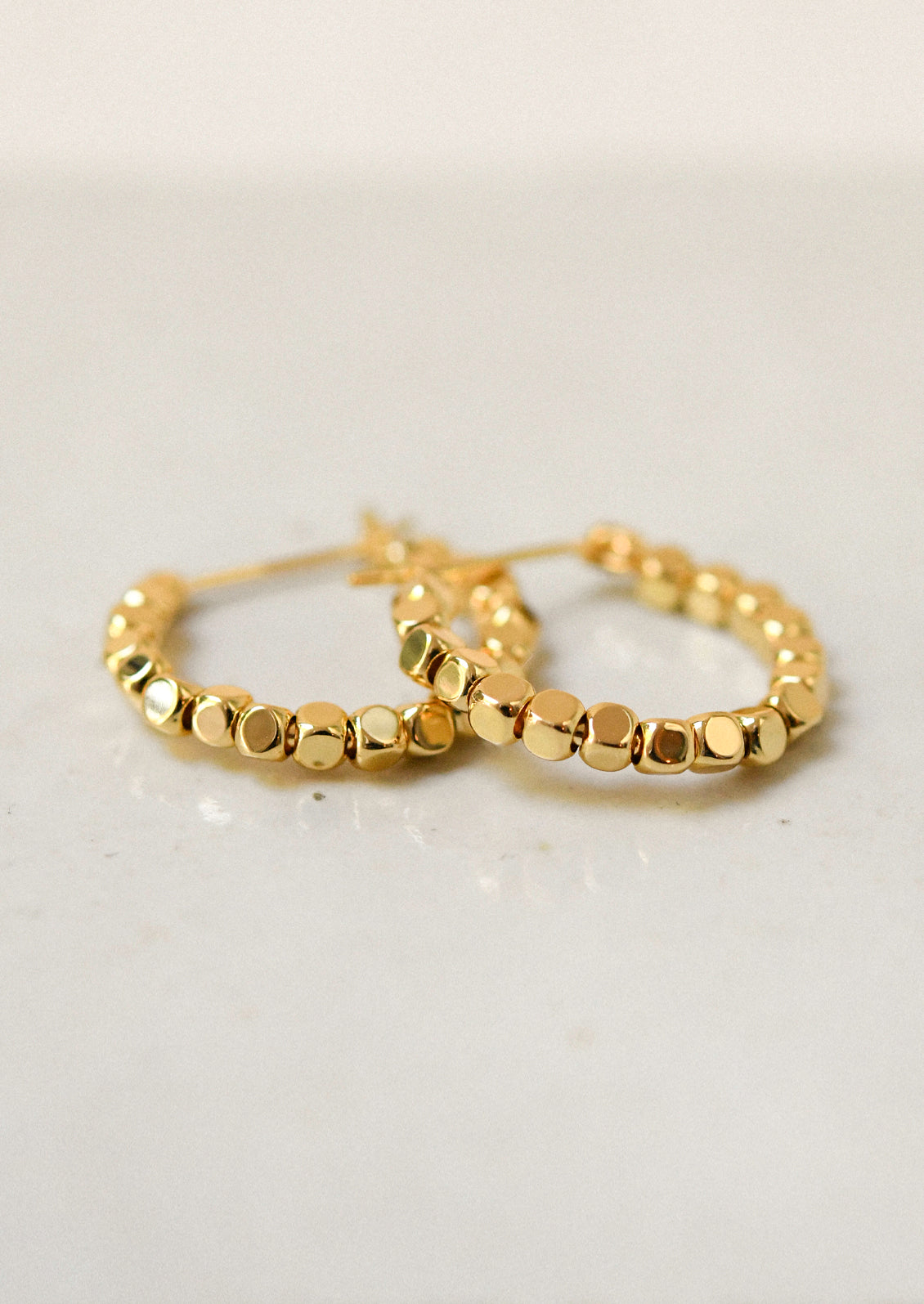 A pair of shiny gold hoop earrings.