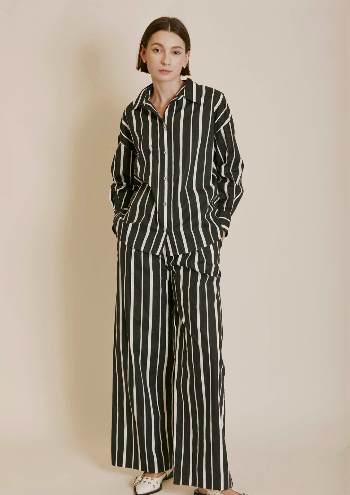 A poplin button front shirt in black with white stripes in varying widths.
