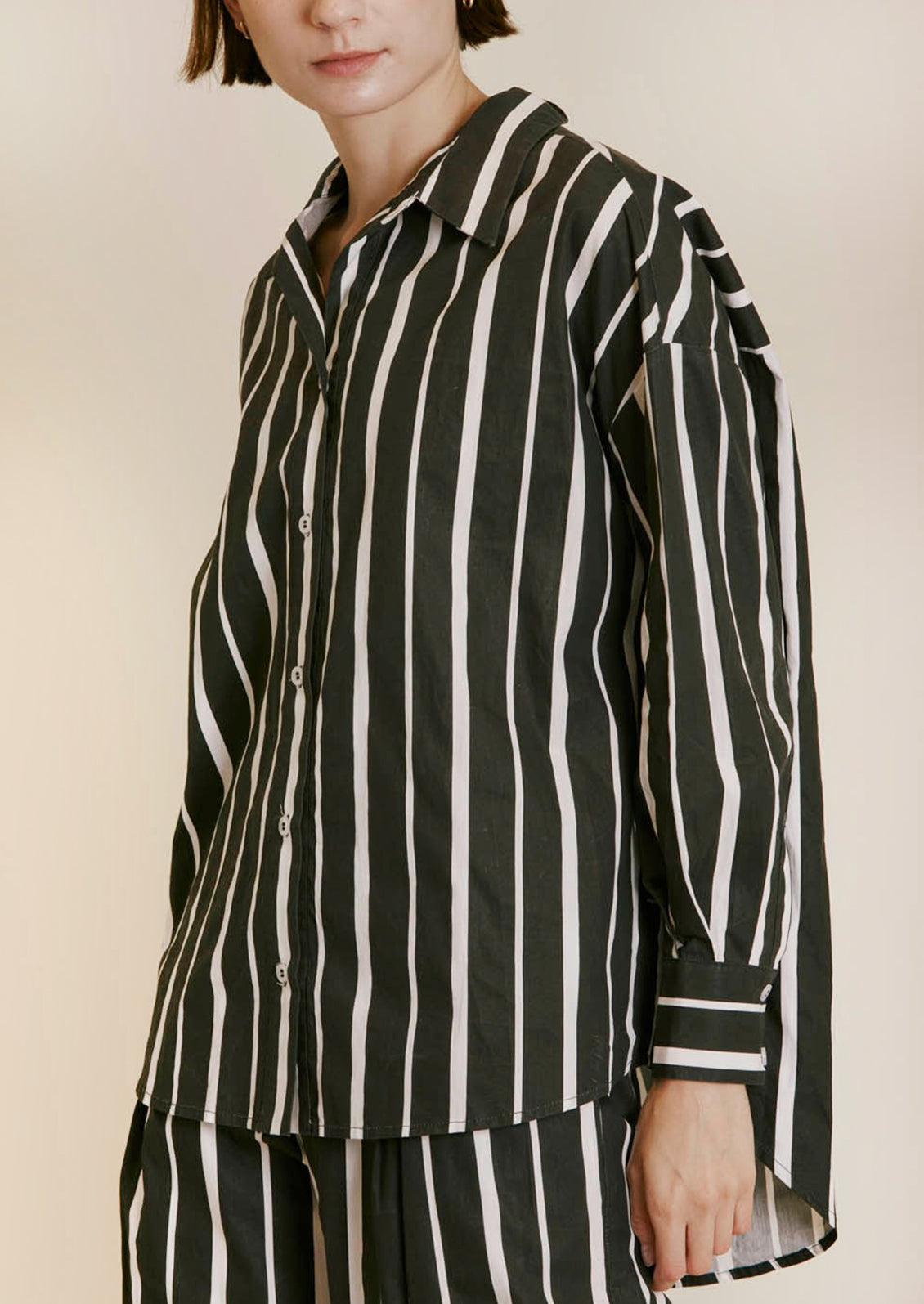 A poplin button front shirt in black with white stripes in varying widths.