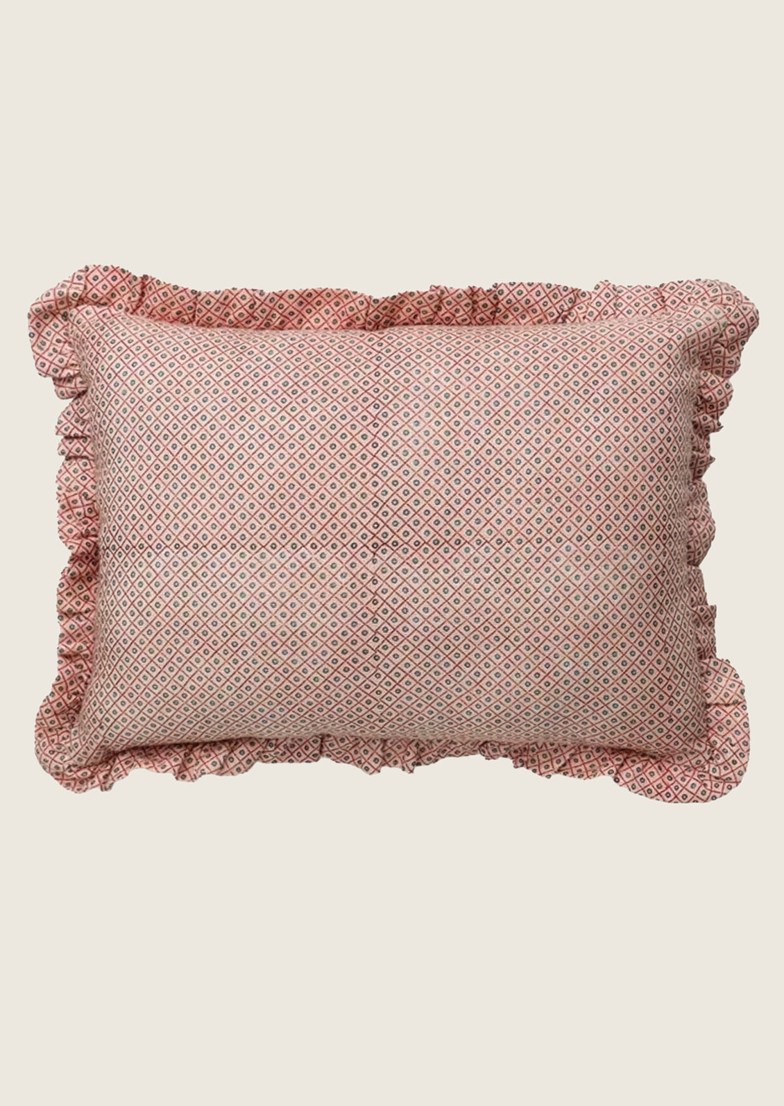 Pink geometric patterned linen pillow with ruffled edges.