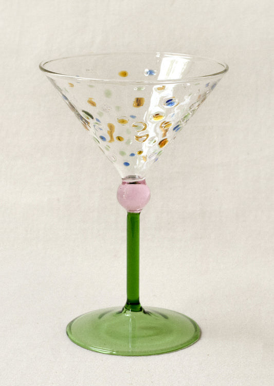 Decorative martini glass with colorful dots and green stem.
