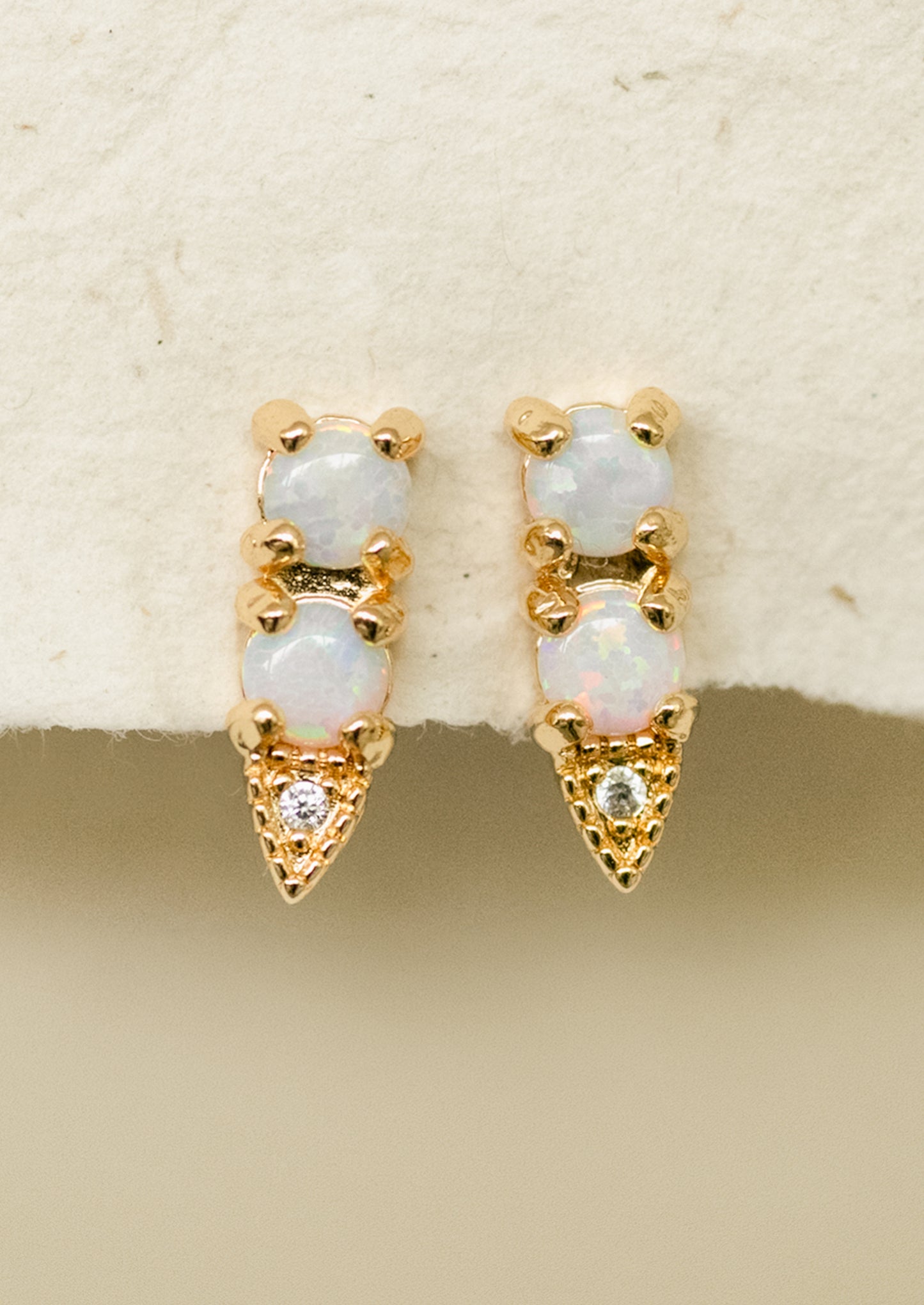 A pair of gold stud earrings with two stacked opal stones.