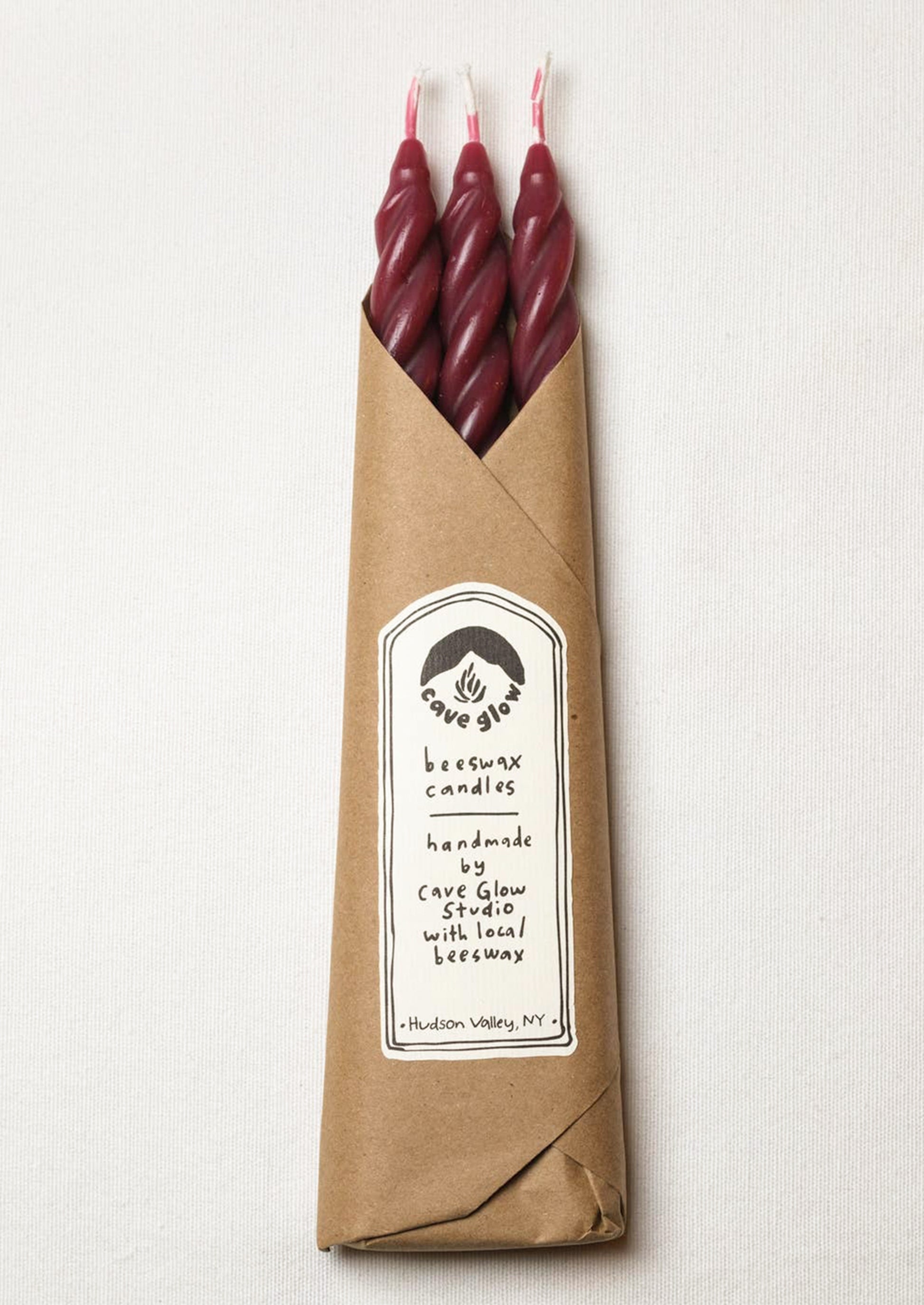 A set of three spiral textured taper candles in dark red color.
