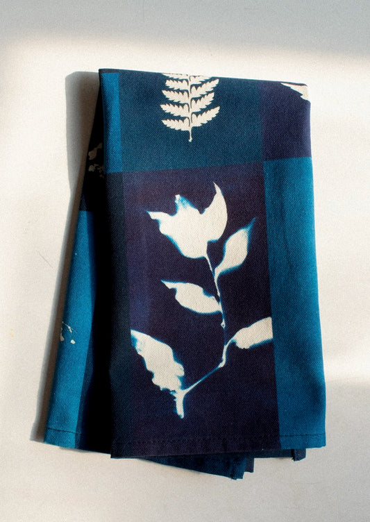 Folded fabric with white leaf patterns on a blue and navy background