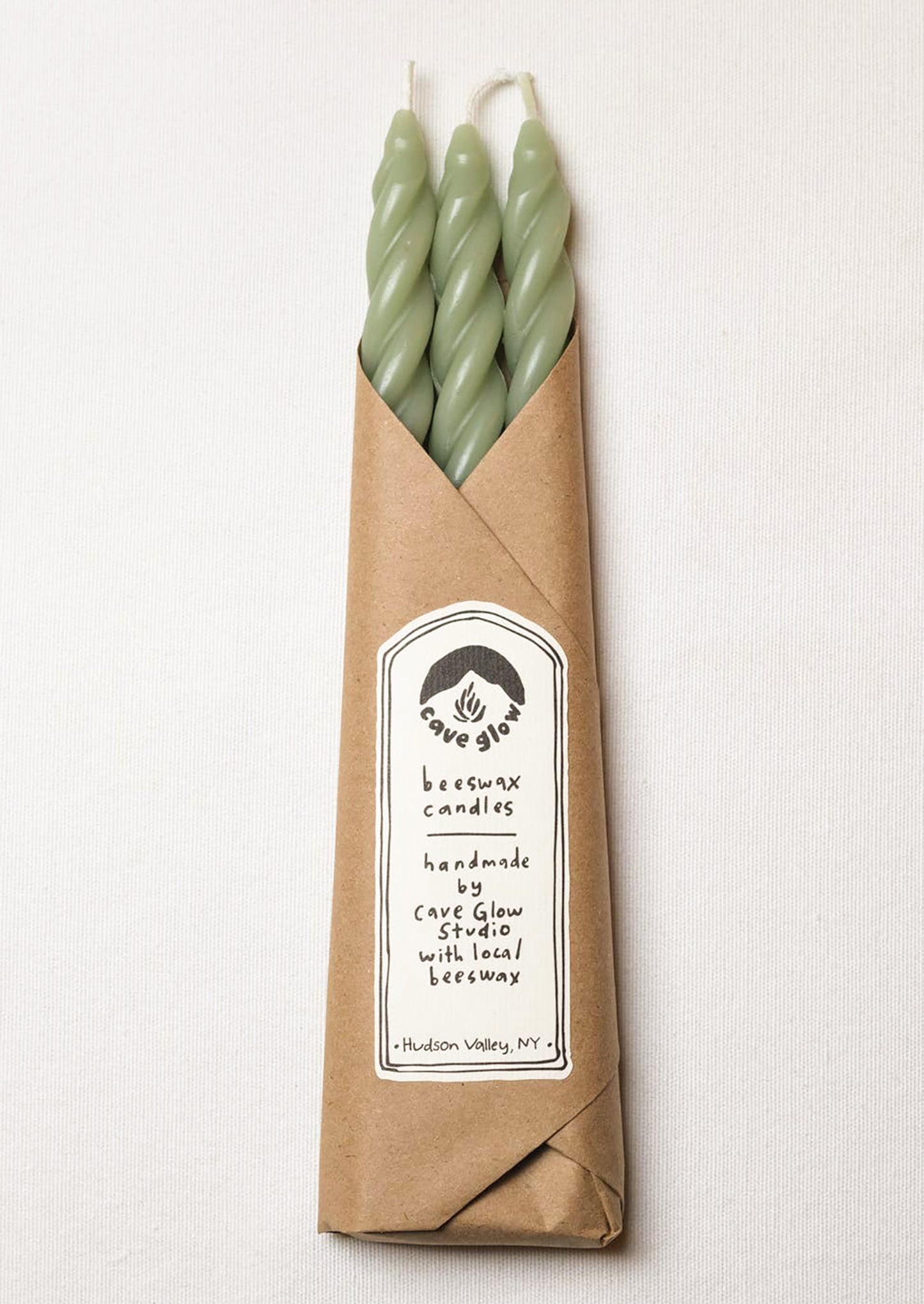 A set of three spiral textured taper candles in sage green color.