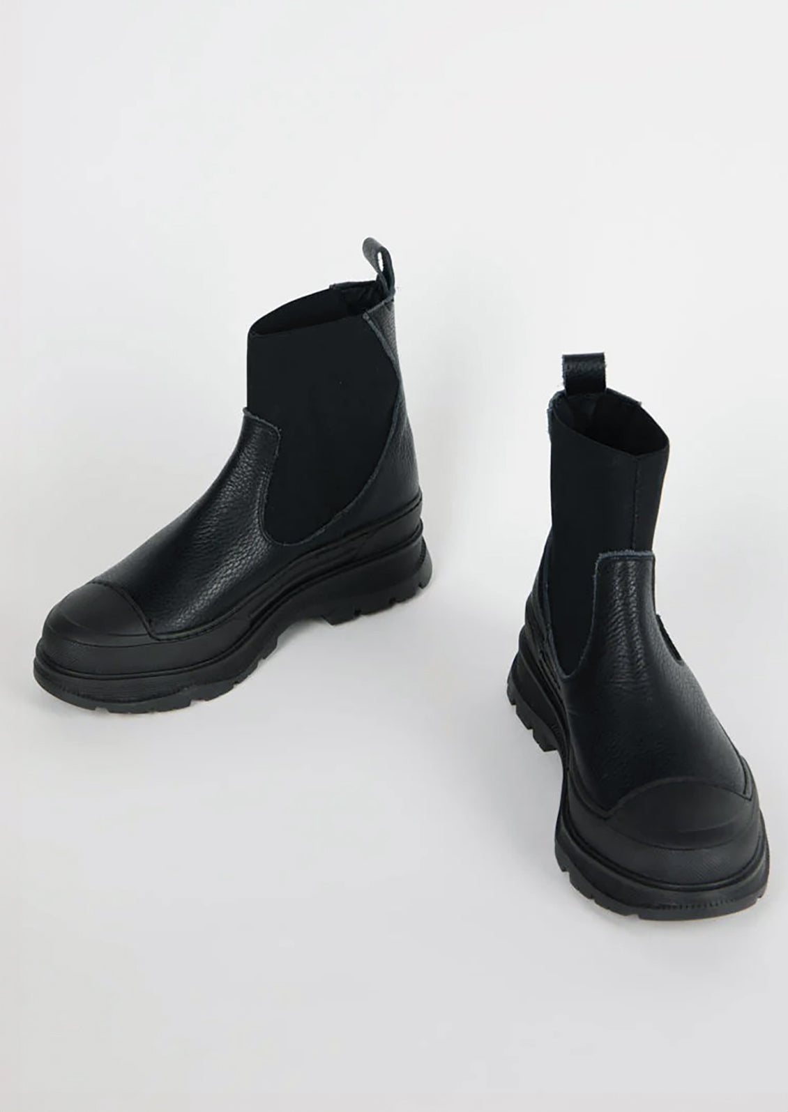A pair of black boots with elastic ankle, rubber cap toe and chunky lug sole.
