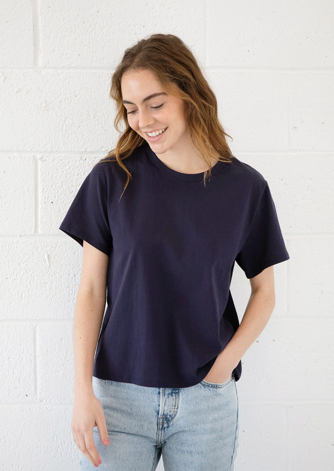 A woman wearing a short sleeve cotton t-shirt in navy blue.