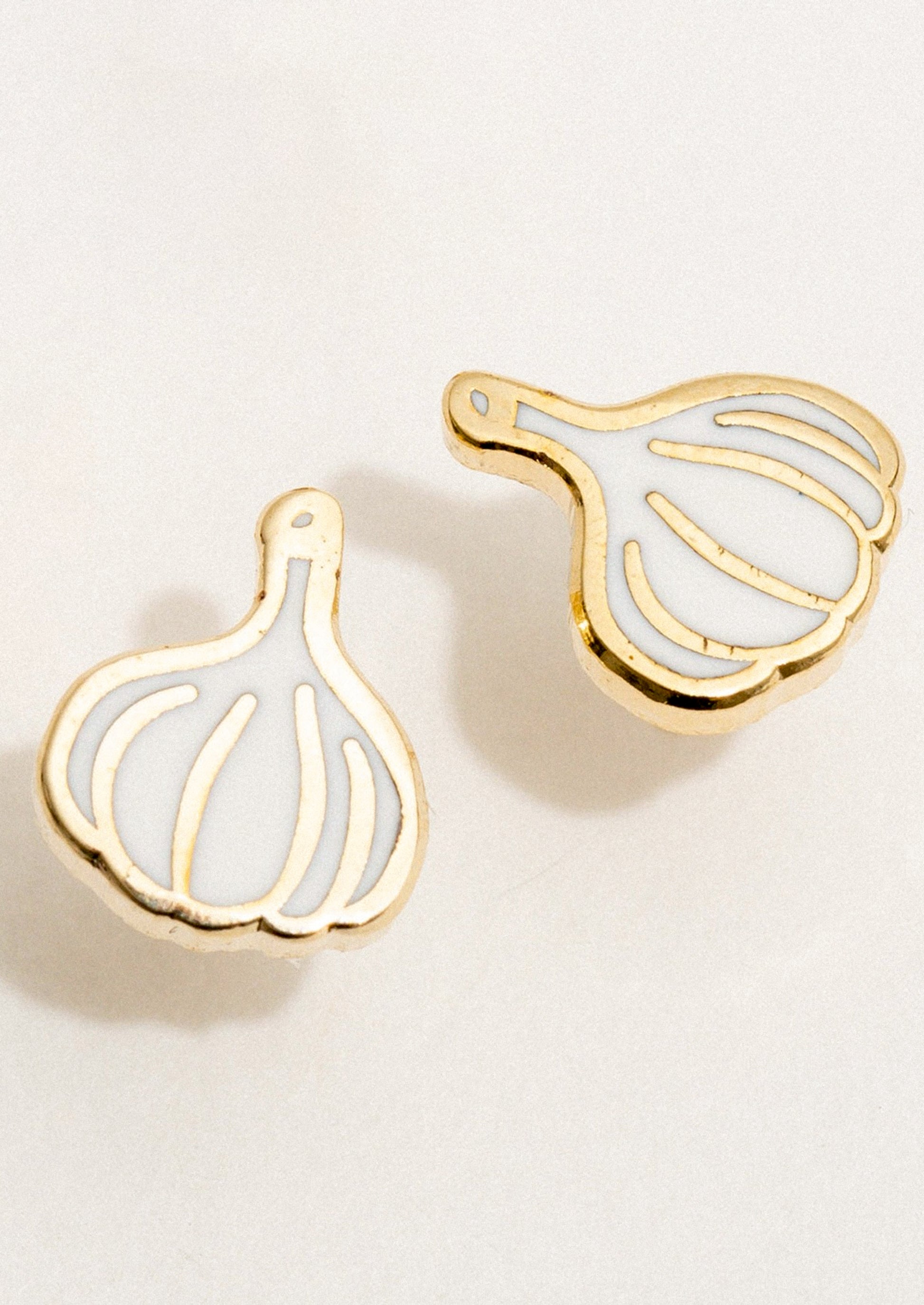 A pair of stud earrings in enamel depicting a bulb of garlic.