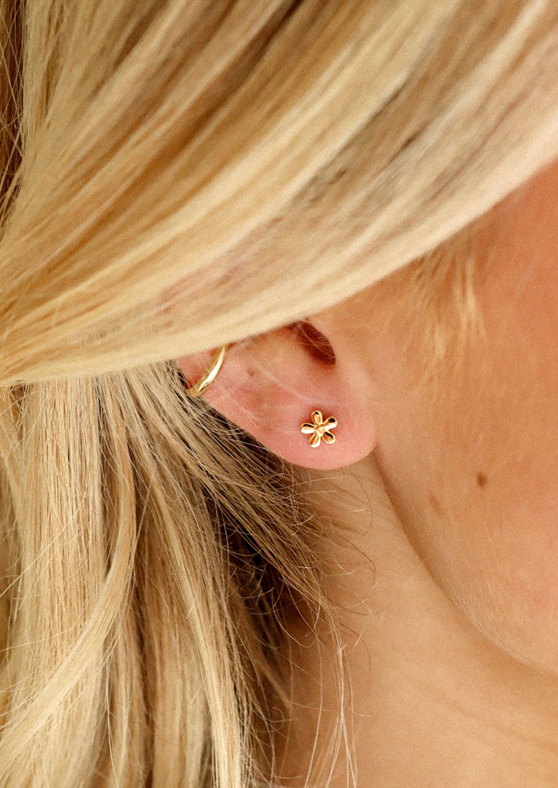 A pair of flower shaped stud earrings in gold.