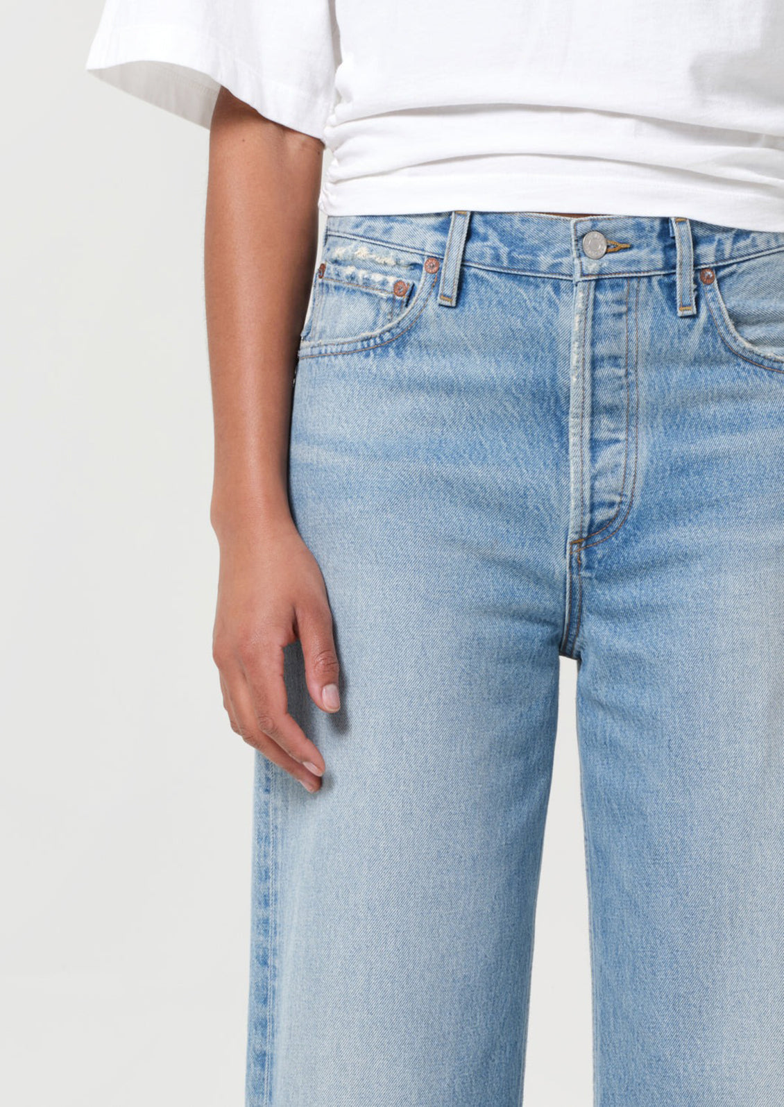 Light blue jeans worn by a person on a plain background